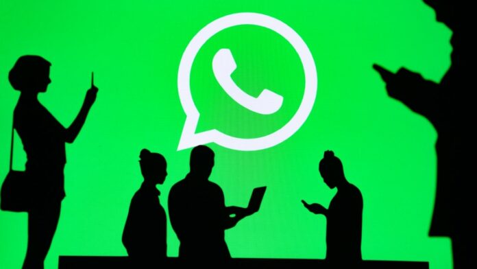 Logo Whatsapp avec l'ombre d'utilisateurs de l'application sur leur smartphone